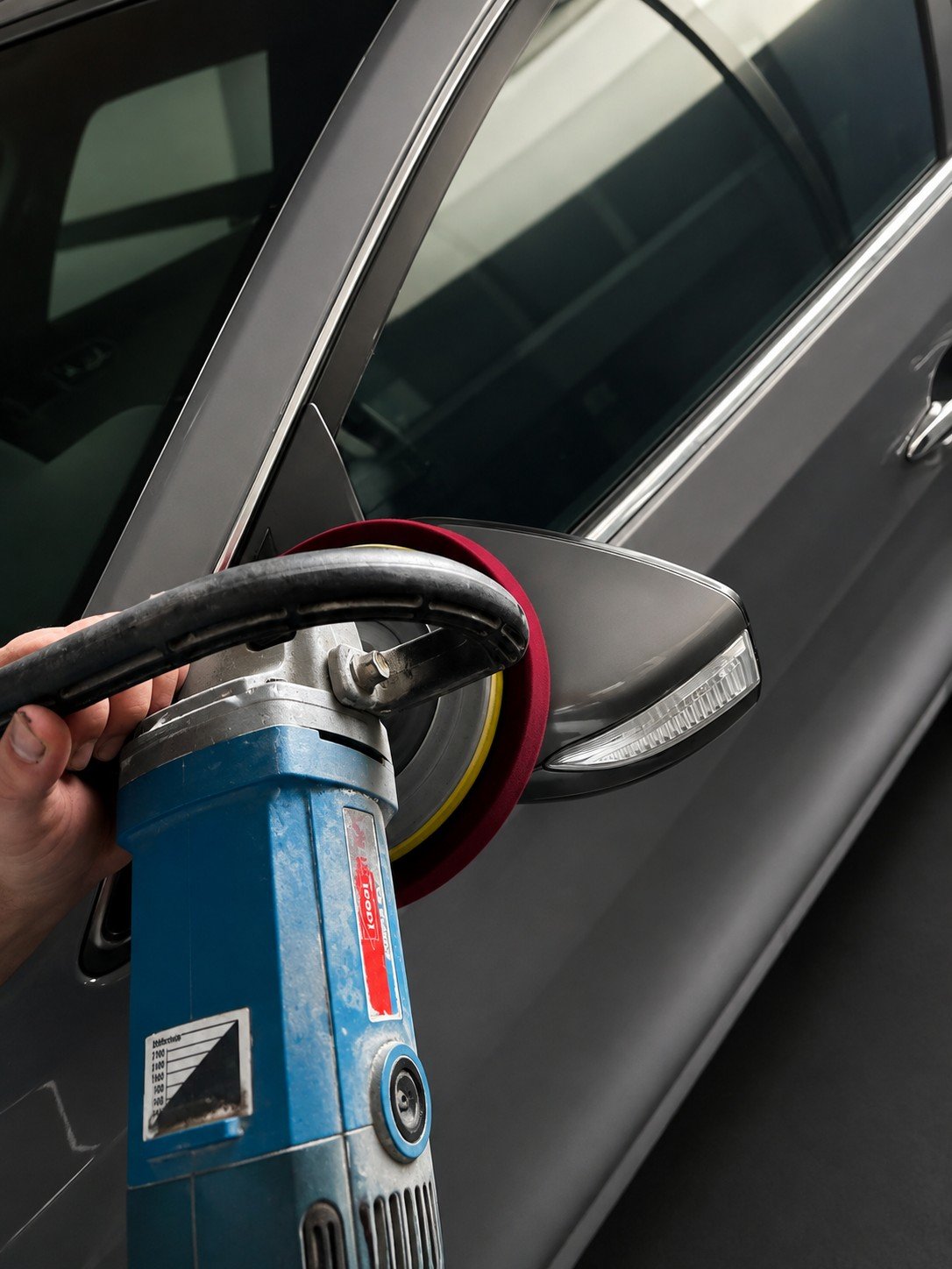 Polishing a vehicle panel with a machine polisher in the Paintora workshop